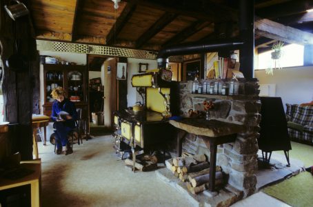 An open-plan kitchen-dining-living area in the home’s center maximized light. Woodstoves backed onto a 5-ton central stone mass.