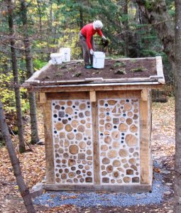 Jaki plants the living roof on the Hermit’s Hut guest house at Earthwood. 